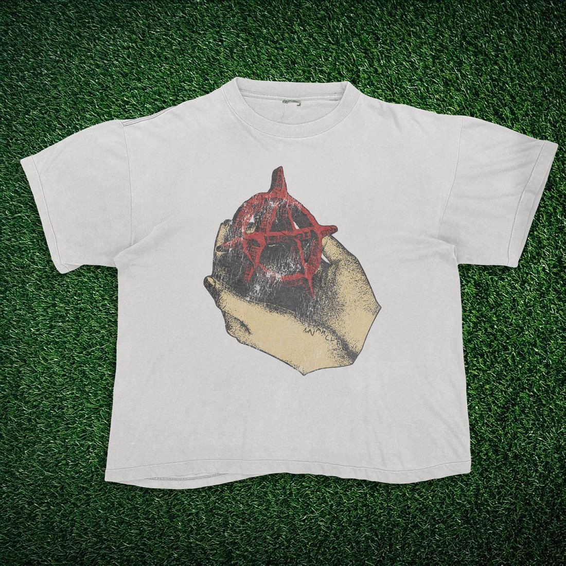 White tee with a hand holding a spray-painted anarchy symbol
